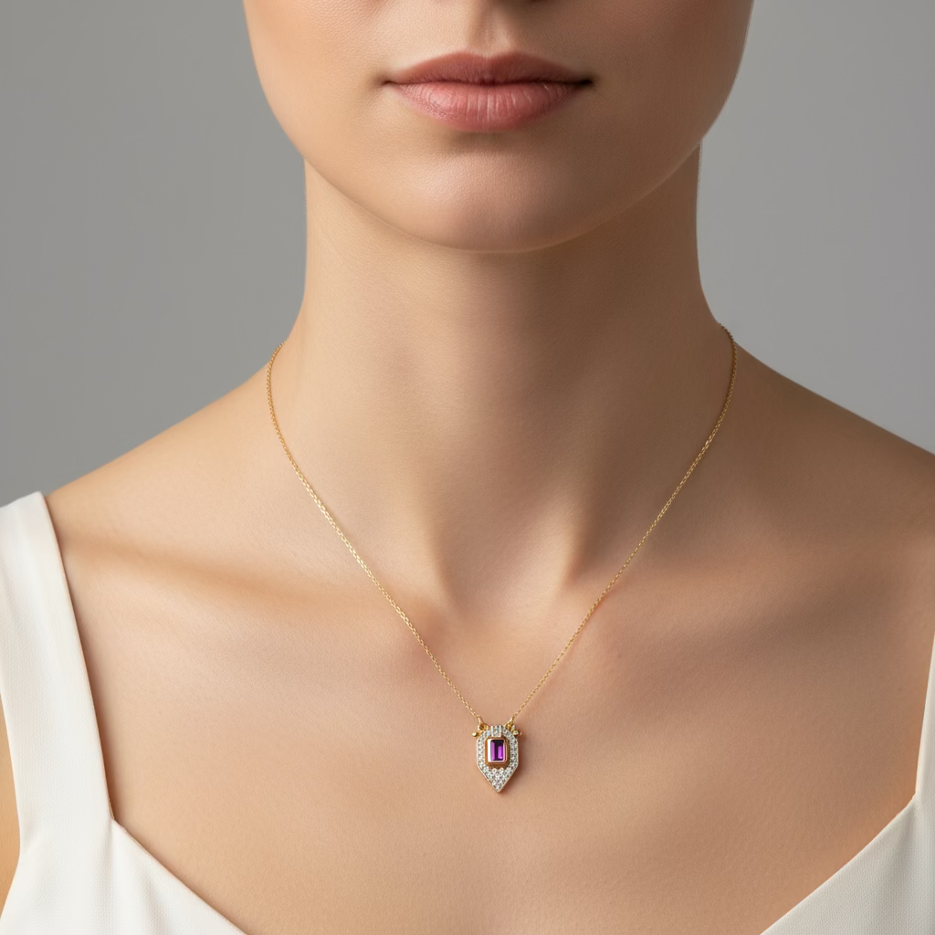 Altın zincirli, ortasında yakut renkli baget taş bulunan zirkon detaylı kalkan kolye – SAVAYA zarif takı koleksiyonu.